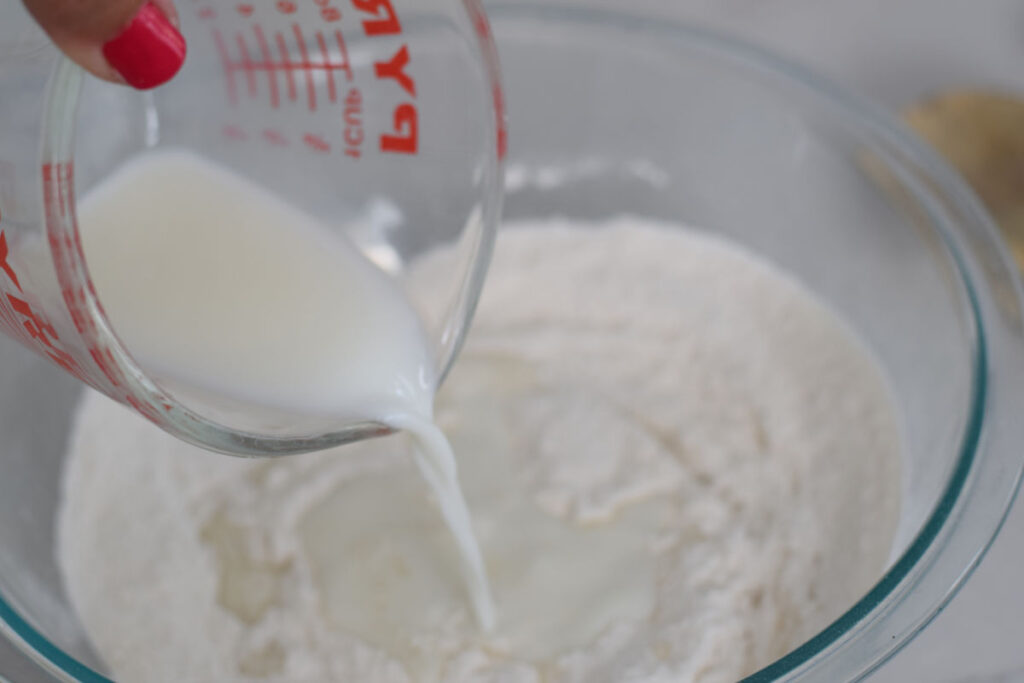 making berry cobbler recipe pouring milk