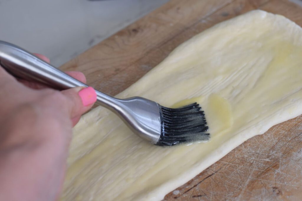 brushing butter on dough 