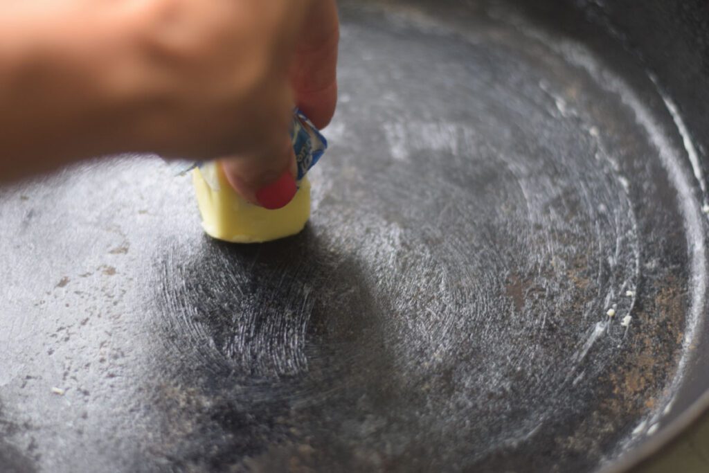 rubbing butter onto skillet 