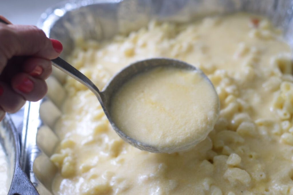 adding cheese sauce to macaroni