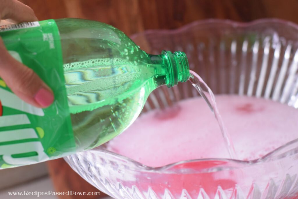 pouring 7-UP into pink lemonade punch